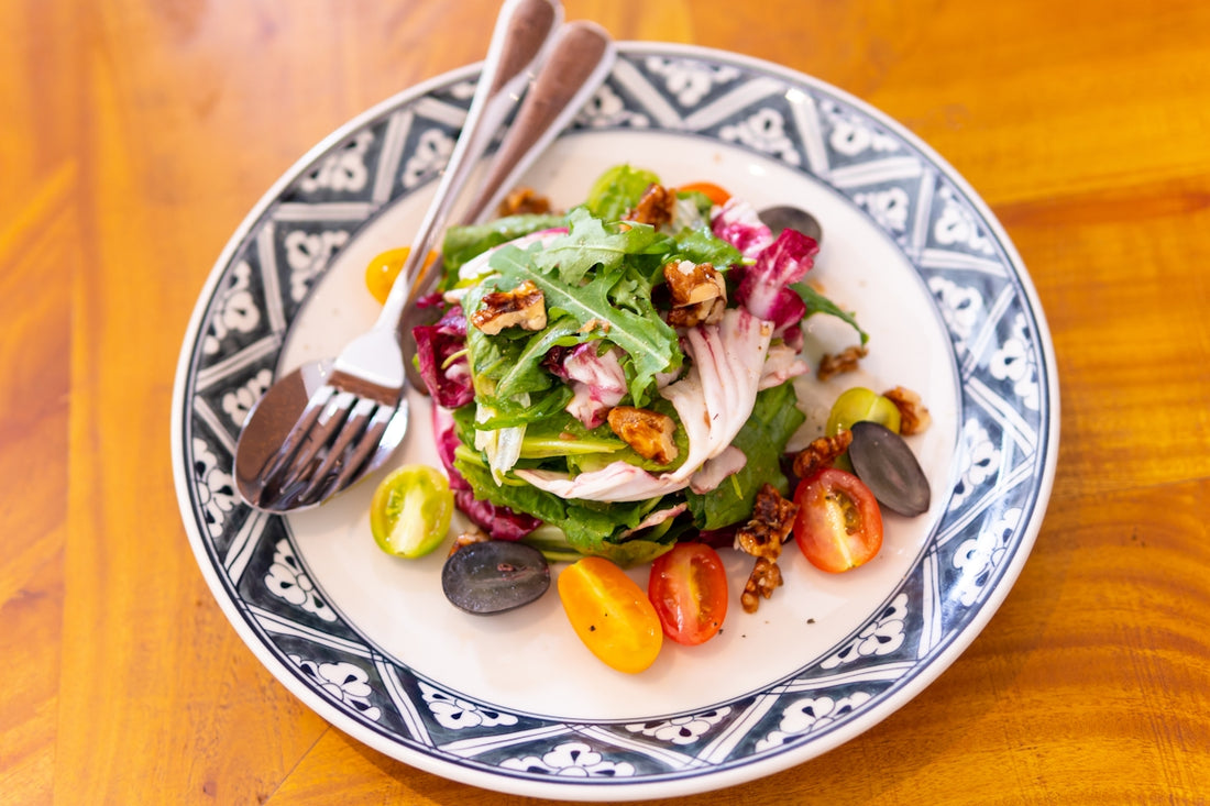 a white plate topped with a salad and a fork