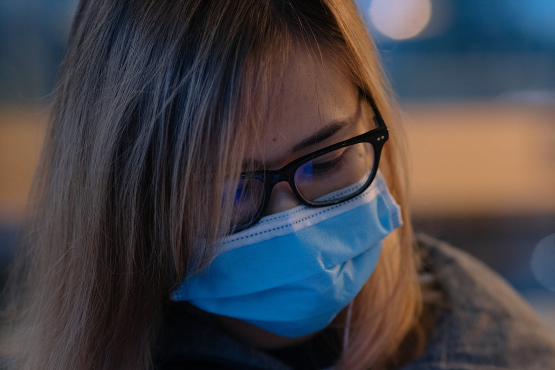 a woman wearing a face mask and glasses