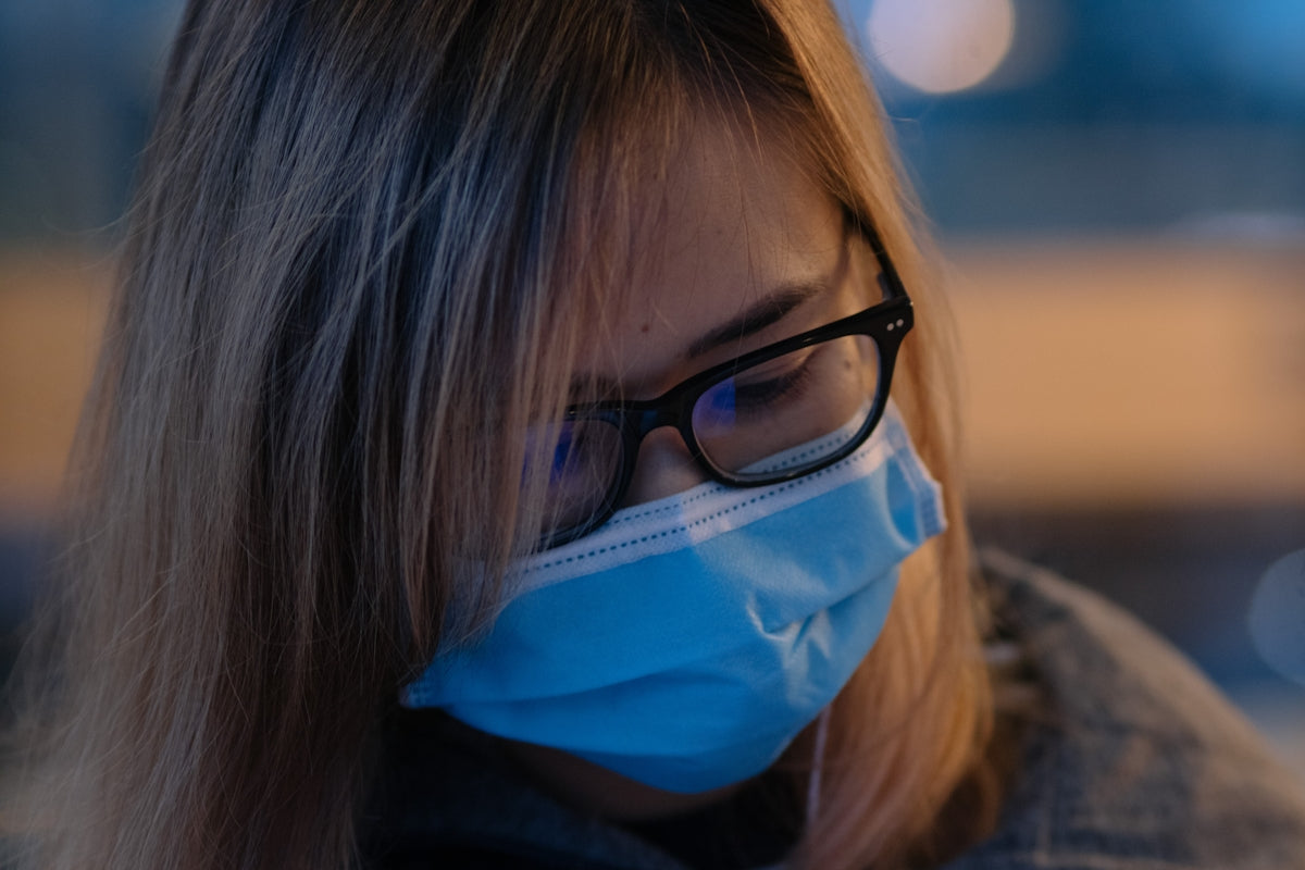 a woman wearing a face mask and glasses