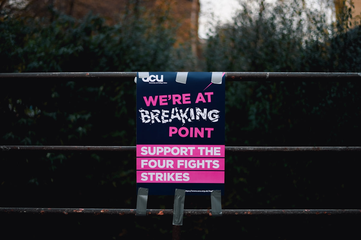 a sign on a fence that says we're at breaking point support the four