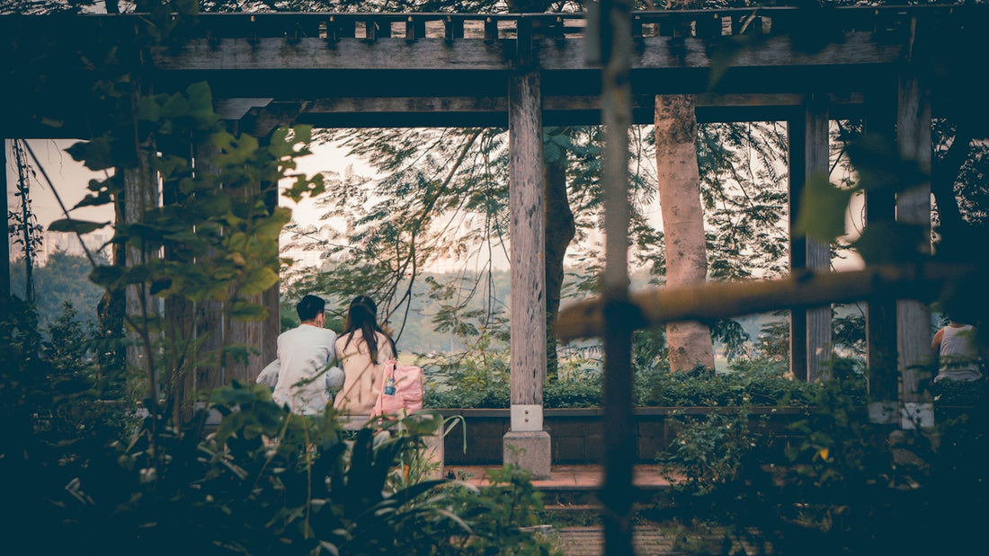 a couple of people standing under a wooden structure