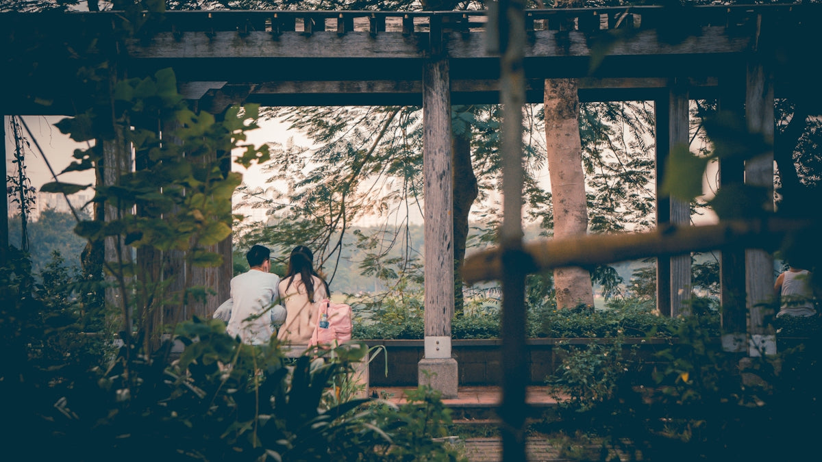 a couple of people standing under a wooden structure