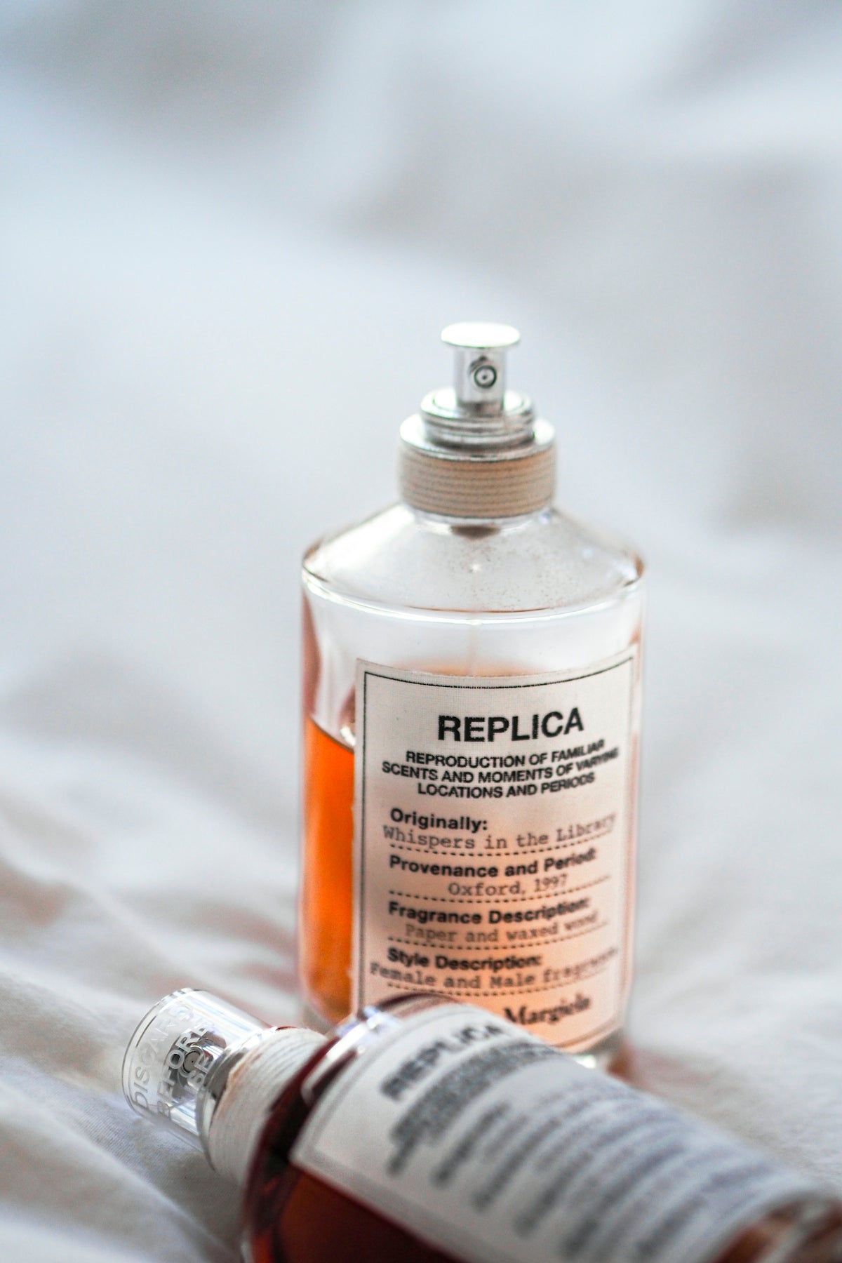 a bottle of liquid sitting on top of a bed