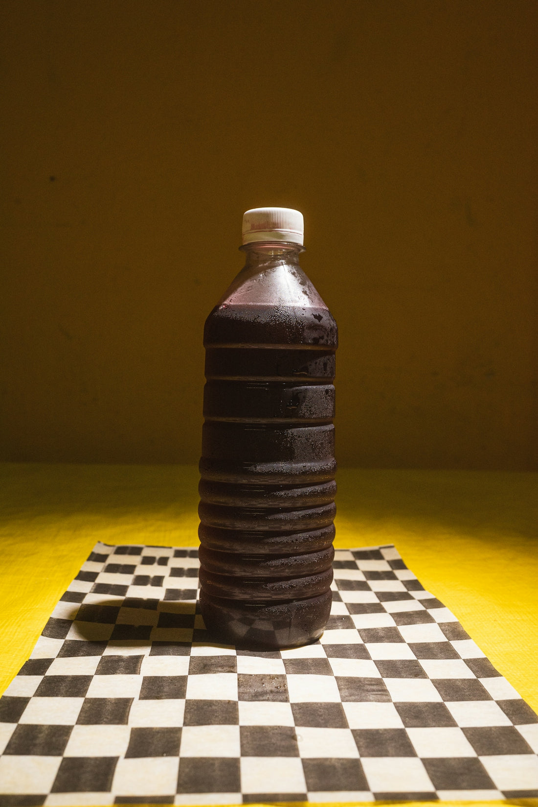 A plastic bottle sitting on top of a chess board