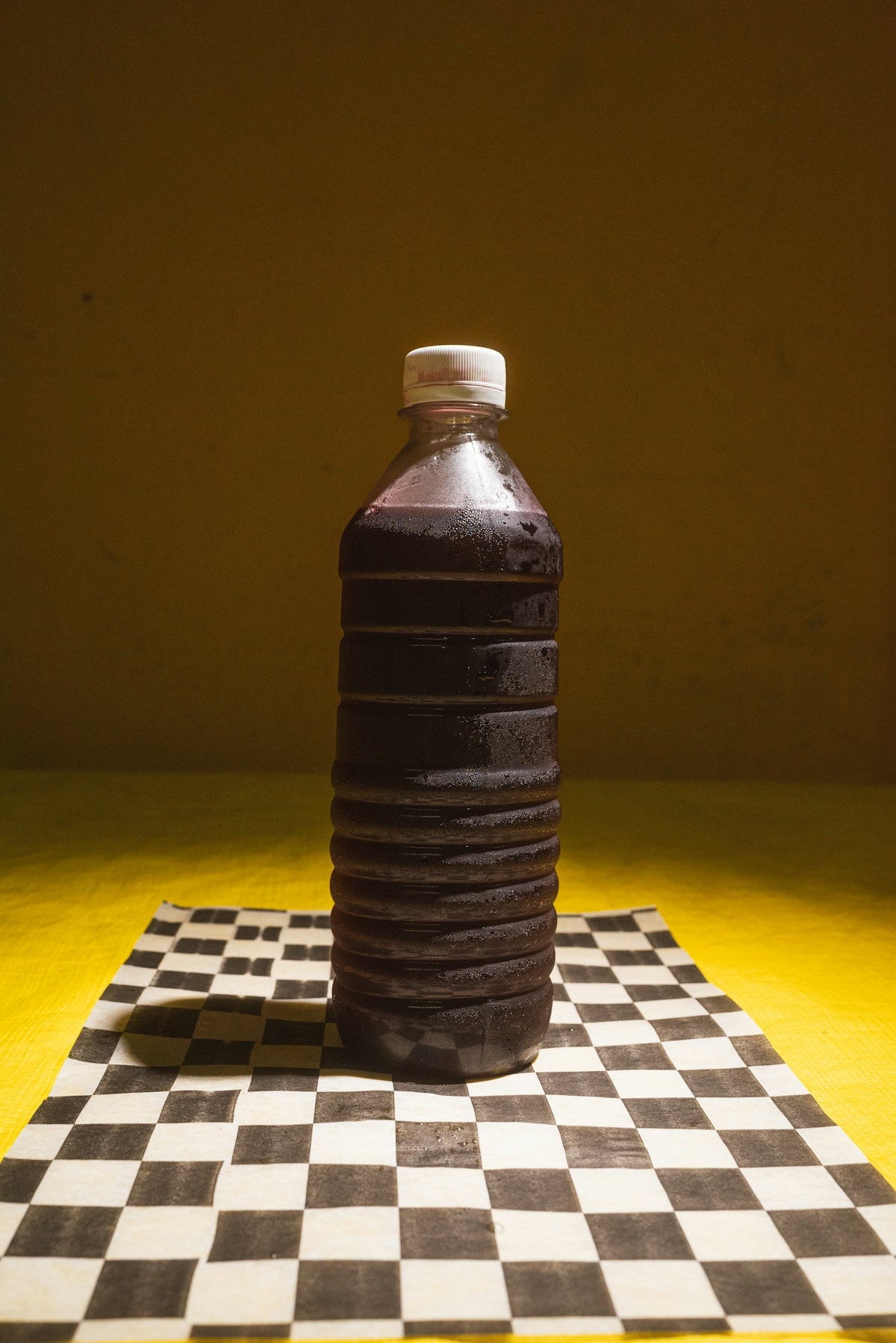 A plastic bottle sitting on top of a chess board