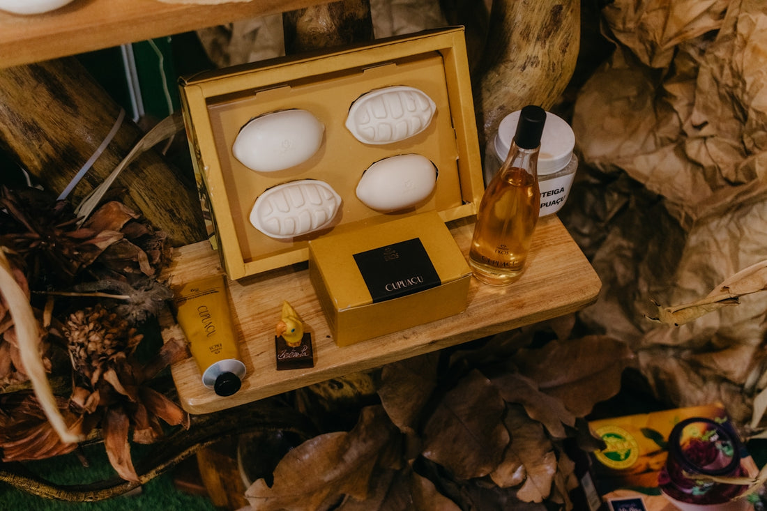 A wooden tray displays natural soaps, oil, and cosmetic products.